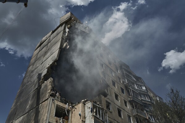 Emergency services work at a scene after a missile hit an apartment building in Kryvyi Rih, Ukraine, Monday, July 31, 2023. (AP Photo/Libkos)