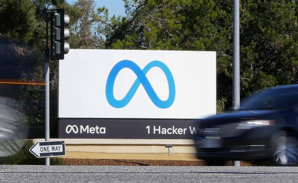 FILE - A car passes Facebook's new Meta logo on a sign at the company headquarters on Oct. 28, 2021, in Menlo Park, Calif. A group of Democratic state election officials sent a letter to the parent company of Facebook on Thursday, May 2, 2024, asking it to stop allowing ads that claim the 2020 presidential election was stolen. (AP Photo/Tony Avelar, File)