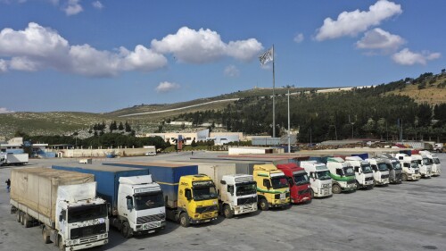 FILE - Trucks loaded with United Nations humanitarian aid for Syria following a devastating earthquake are parked at Bab al-Hawa border crossing with Turkey, in Syria's Idlib province, on Feb. 10, 2023. The U.N. secretary general is hoping that the Security Council will vote later this month to keep a key border crossing from Turkey to Syria’s rebel-held northwest open for critical aid deliveries for a period of one year instead of six months. (AP Photo/Ghaith Alsayed, File)