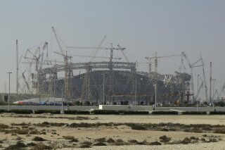 FILE - In this Dec. 20, 2019 file photo, construction is underway at the Lusail Stadium, one of the 2022 World Cup stadiums, in Lusail, Qatar. A U.N. labor body says new labor rules in the energy-rich nation of Qatar “effectively dismantles” the country’s long-criticized “kafala” employment system. The International Labor Organization said Sunday, Aug. 30, 2020, that as of now, migrant workers can change jobs before the end of their contracts without obtaining the permission of their current employers. (AP Photo/Hassan Ammar, File)