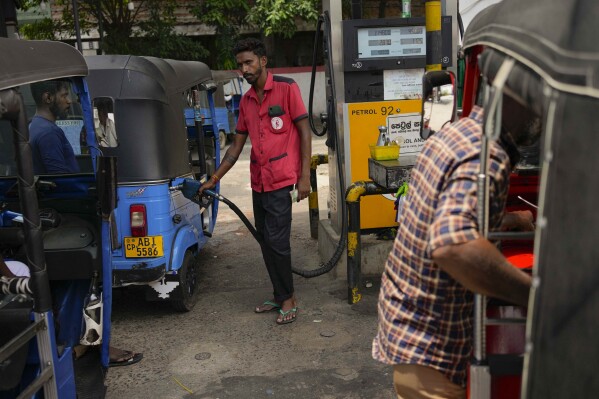 FILE - A man fills gas into a vehicle at a fuel station in Colombo, Sri Lanka, on March 29, 2023. Sri Lanka said Wednesday Nov. 29, 2023 that it has reached an agreement in principle with a group of creditors including India and Japan on debt restructuring, a crucial move toward unlocking a second installment of a $2.9 billion bailout package from the International Monetary Fund. (AP Photo/Eranga Jayawardena, File)