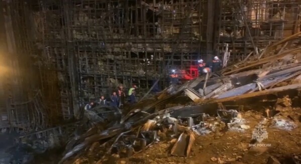 In this photo taken from video released by Russian Emergency Ministry Press Service on Tuesday, March 26, 2024, rescuers work in the burned concert hall after a terrorists attack on the building of the Crocus City Hall on the western edge of Moscow, Russia. (Russian Emergency Ministry Press Service via AP)