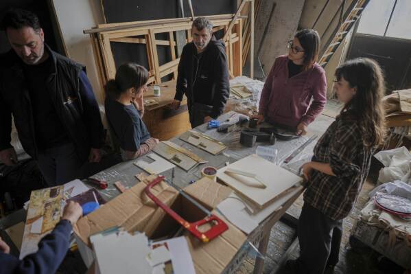 Danilo Mancini, director of set production, left, oversees designers as they work on the project of stage canvases in the "Teatro dell' Opera" opera house warehouse, in Rome, Thursday, April 10, 2025. (AP Photo/Andrew Medichini)
