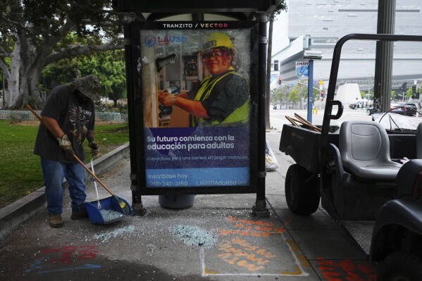 Cleanup continues after a night of protests in downtown Los Angeles, Monday, June 9, 2025. (AP Photo/Damian Dovarganes)