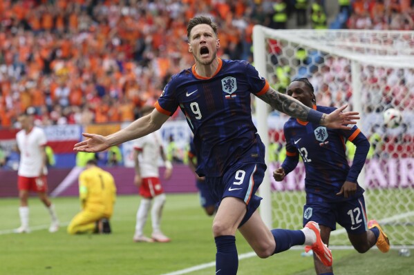 Wout Weghorst of the Netherlands, left, celebrates his side's second goal with his team mates during a Group D match between Poland and the Netherlands at the Euro 2024 soccer tournament in Hamburg, Germany, Sunday, June 16, 2024. (Jens Buettner/dpa via AP)