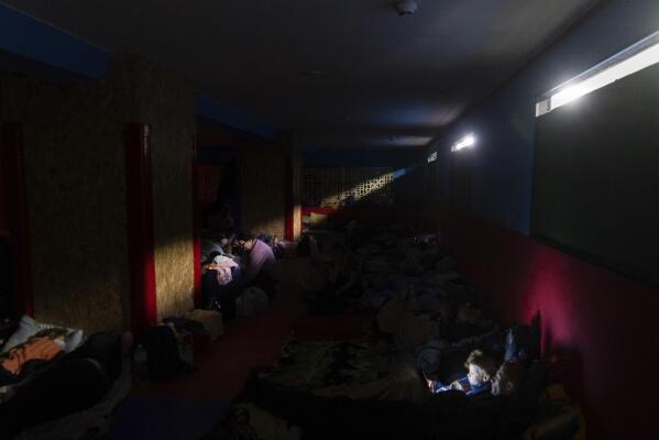 People prepare for the night in the improvised bomb shelter in a sports center, in Mariupol, Ukraine, late Sunday, Feb. 27, 2022. (AP Photo/Mstyslav Chernov)