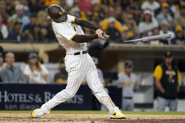 San Diego Padres' Manny Machado (13) puts the swag chain on Ha-Seong Kim  (7) after he hit a solo home run during the fifth inning of a baseball game  against Los Angeles