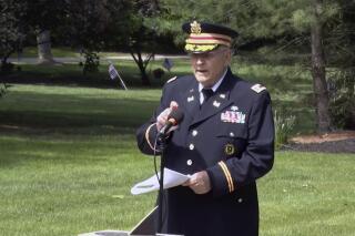 In this frame grab from video provided by Hudson Community Television, retired Army Lt. Col. Barnard Kemter taps the microphone after organizers turned off the audio during his speech at a Memorial Day ceremony, Monday, May 31, 2021, in Hudson, Ohio. Organizers of the ceremony turned off Kemter's microphone when he began talking about how freed Black slaves had honored fallen soldiers soon after the Civil War. (Hudson Community Television via AP)