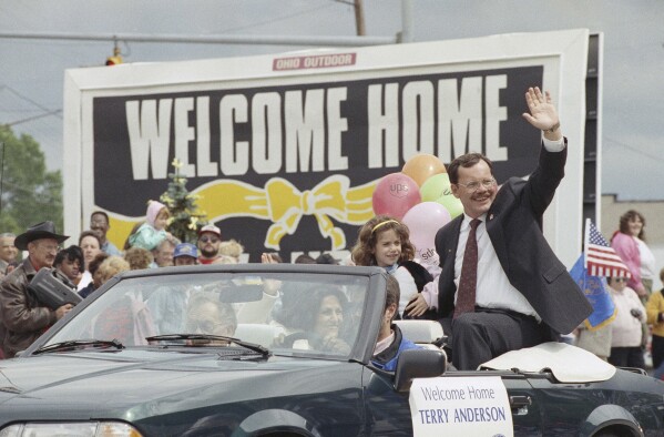 FILE - Former hostage Terry Anderson waves to the crowd as he rides in a parade in Lorain, Ohio, June 22, 1992. Anderson, the globe-trotting Associated Press correspondent who became one of America’s longest-held hostages after he was snatched from a street in war-torn Lebanon in 1985 and held for nearly seven years, died Sunday, April 21, 2024. He was 76. (AP Photo/Mark Duncan, File)