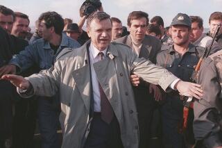 FILE - The former speaker of Russia's parliament Ruslan Khasbulatov makes his way through a crowd of people, on his way to Grozny airport, Sept. 29, 1995. Ruslan Khasbulatov, who led a rebellion against Russia's first post-Soviet president, has died. He was 80. Khasbulatov's death was reported Tuesday Jan. 3, 2023, by Russian state television. (AP Photo/File)