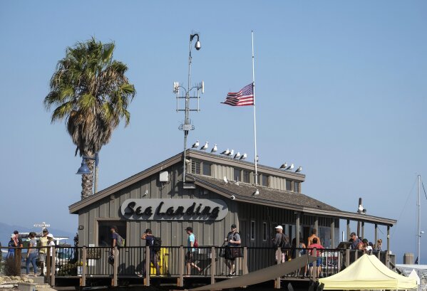 A U.S. flag flies at half-staff on the Sea Landing, where the Truth Aquatics office is situated, at Santa Barbara Harbor in Santa Barbara, Calif., Monday, Sept. 2, 2019. A boat carrying recreational scuba divers that caught a fire early Monday while anchored near Santa Cruz Island off the Southern California coast was owned and operated by Truth Aquatics. (AP Photo/Ringo H.W. Chiu)