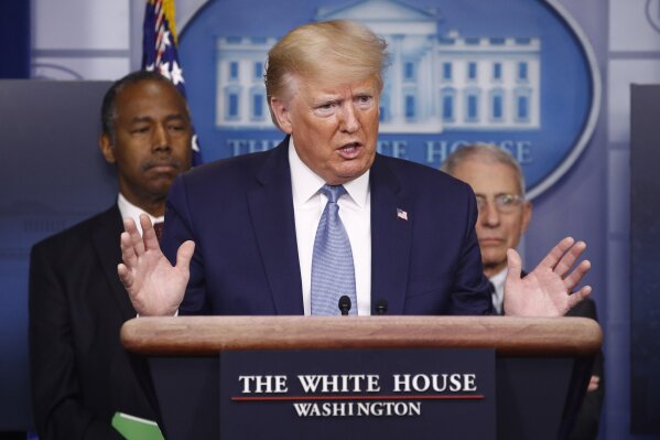 President Donald Trump speaks during a coronavirus task force briefing at the White House, Saturday, March 21, 2020, in Washington.Housing and Urban Development Secretary Ben Carson, left, and Director of the National Institute of Allergy and Infectious Diseases Dr. Anthony Fauci listen. (AP Photo/Patrick Semansky)