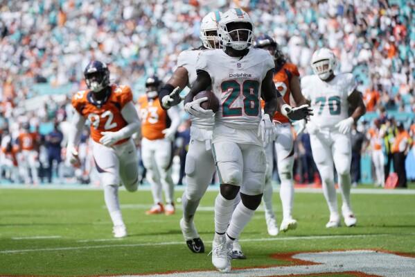 El running back De'Von Achane (28) de los Dolphins de Miami celebra tras anotar un touchdown ante los Broncos de Denver, el domingo 24 de septiembre de 2023, en Miami Gardens. (AP Foto/Rebecca Blackwell)