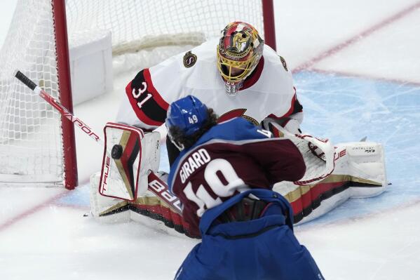 Ottawa Senators goaltender Anton Forsberg, top, makes a save of a shot off the stick of Colorado Avalanche defenseman Samuel Girard, bottom, in the third period of an NHL hockey game Saturday, Jan. 14, 2023, in Denver. (AP Photo/David Zalubowski)