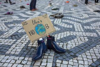 Pairs of shoes with messages about environment protection are placed by activists evenly spaced over a square in Lisbon during a global climate protest, Friday, Sept. 25, 2020. (AP Photo/Armando Franca)