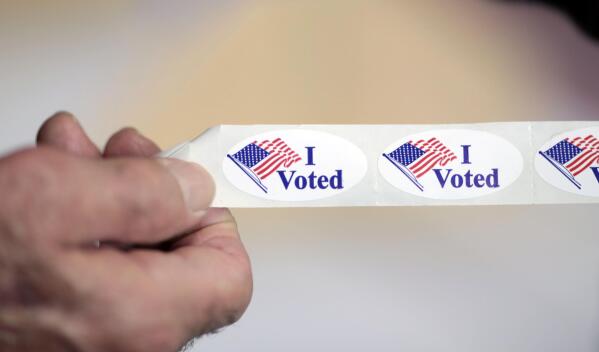 Voters get stickers to show they cast their ballots at the Great Barrington Fire Department polling location on election day on Tuesday, Nov. 8, 2022. (Stephanie Zollshan/The Berkshire Eagle via AP)