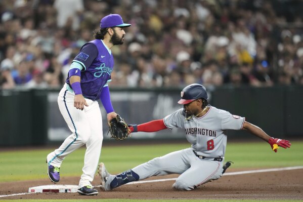 Washington Nationals' José Tena (8) slides safely into third base with a triple as Arizona Diamondbacks third baseman Eugenio Suárez waits for a possible throw during the third inning of a baseball game Friday, May 30, 2025, in Phoenix. (AP Photo/Ross D. Franklin)
