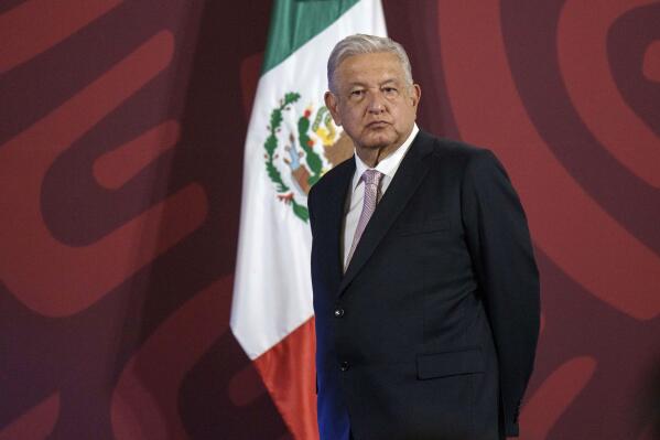 FILE - Mexican President Andres Manuel Lopez Obrador stands on a stage from where he gives his daily press conference at the National Palace in Mexico City, July 8, 2022. Promoting coal is part of Lopez Obrador’s effort to shore up the state-owned power utility, the Federal Electricity Commission. Not only was it questioned by environmentalists; many also said it endangered miners.  (AP Photo/Moises Castillo, File)