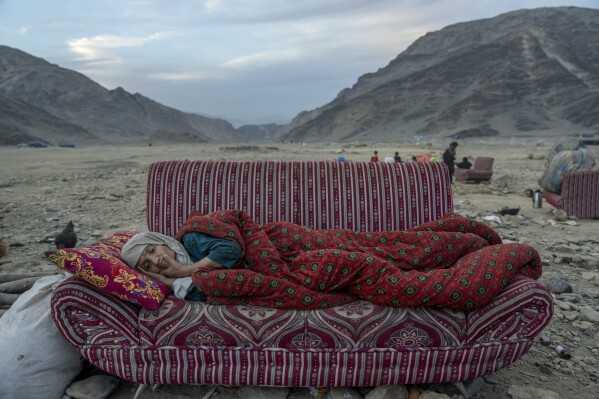 An Afghan refugee rests in the desert next to a camp near the Torkham Pakistan-Afghanistan border, in Torkham, Afghanistan, Friday, Nov. 17, 2023. (AP Photo/Ebrahim Noroozi)