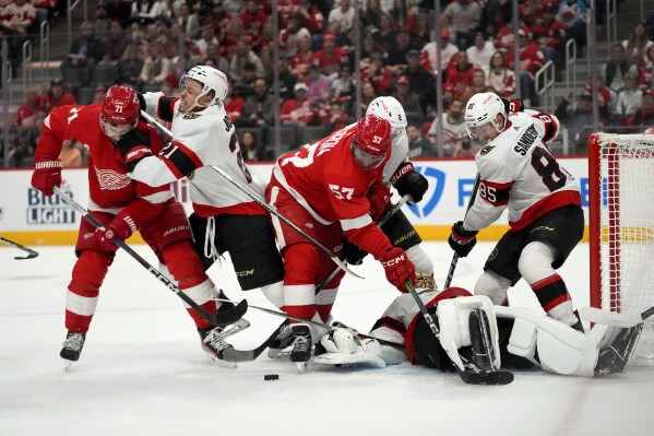 Ottawa Senators right wing Mathieu Joseph (21) hits Detroit Red Wings center Dylan Larkin (71) in the first period of an NHL hockey game Saturday, Dec. 9, 2023, in Detroit. (AP Photo/Paul Sancya)