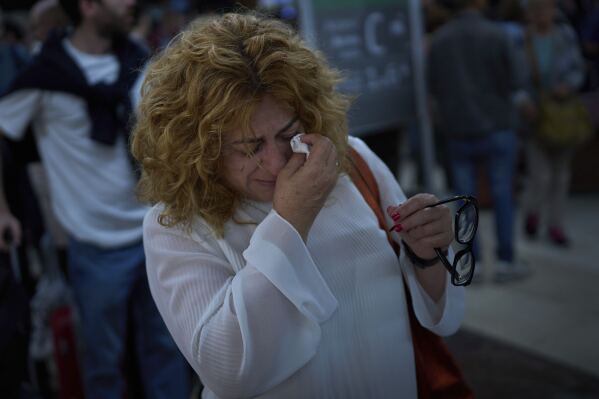 Paquita Gonzalez llora mientras espera noticias sobre salidas de tren tras pasar toda la noche en la estación de Sants en Barcelona, España, el martes 29 de abril de 2025. (AP Foto/Emilio Morenatti)