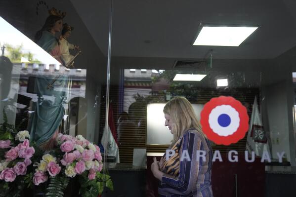 Attorney General of Paraguay Sandra Quiñonez prays to a Virgin Mary statue at the entrance of her office after she found out about the killing during his honeymoon in Colombia of Paraguayan prosecutor Marcelo Pecci, in Asuncion, Paraguay, Tuesday, May 10, 2022. (AP Photo/Jorge Saenz)