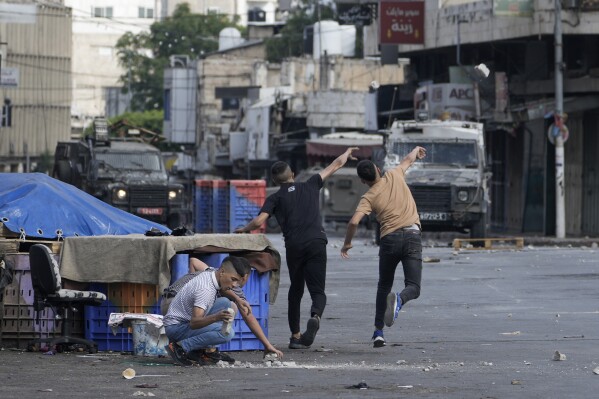 FILE - Palestinians clash with Israeli security forces during a military raid in the West Bank city of Nablus, on July 7, 2023. Palestinian factions were meeting Sunday July 30, 2023 in Egypt to discuss reconciliation efforts as violence in the occupied West Bank surged between Israel and Palestinian militants. (AP Photo/Majdi Mohammed, File)