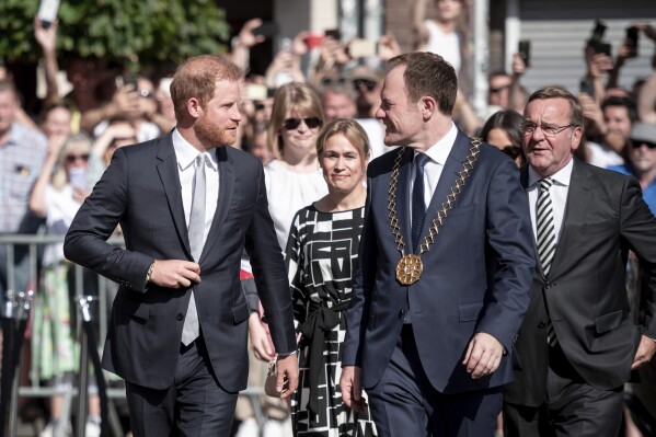 Britain's Prince Harry, front left, arrives with Duesseldorf's Lord Mayor Stephan Keller, front right, and German Defense Minister Boris Pistorius, right, at the City Hall in Duesseldorf, Germany, Saturday, Sept. 9, 2023 for the opening of the 6th Invictus Games. Delegations from the 21 participating nations and guests gather at a reception hosted by the Lord Mayor at Duesseldorf City Hall. The Paralympic competition for war-disabled athletes is hosted in Germany for the first time. (Fabian Strauch/dpa via AP)