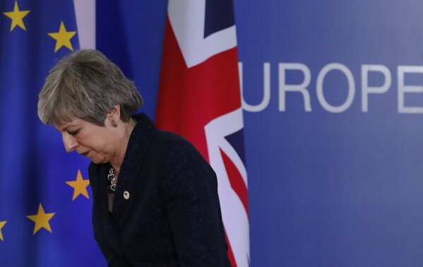 FILE - In this Friday, March 22, 2019 file photo, British Prime Minister Theresa May leaves the podium after addressing a media conference at an EU summit in Brussels. Worn down by three years of indecision in London over Britain's departure from the bloc, EU leaders extended Britain's exit from the original date of March, 29, 2019. Soon after she resigned and was replaced by Boris Johnson and he after a convincing general election victory will oversee Britain's scheduled departure from the EU on Jan. 31, 2020 . (AP Photo/Frank Augstein/File)