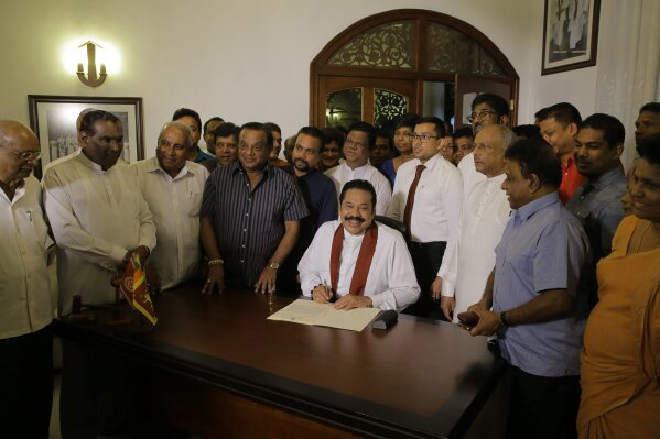 
              Sri Lanka's disputed Prime Minister Mahinda Rajapaksa signs his resignation letter at his residence in Colombo, Sri Lanka, Saturday, Dec. 15, 2018. Rajapaksa resigned on Saturday, saying he wants to end a political impasse over his appointment. (AP Photo/Eranga Jayawardena)
            