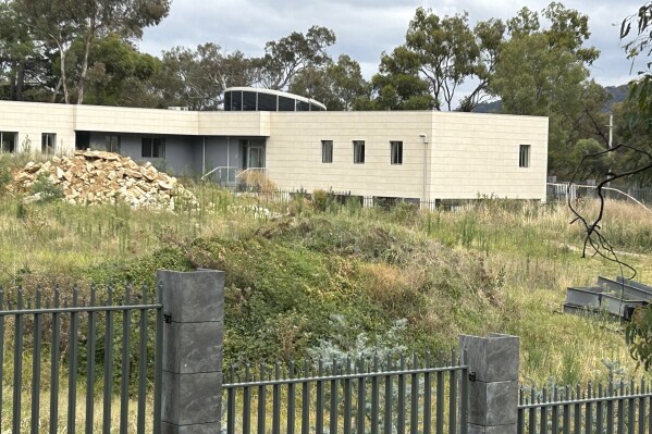 A fence surrounds a seemingly unoccupied building on the grounds of a proposed new Russian embassy near the Australian Parliament in Canberra, Feb. 28, 2023. A suspected lone Russian diplomat was on Friday, June 23, 2023, apparently squatting on the site of the proposed embassy that the Australian government has vetoed. Australian Prime Minister Anthony Albanese dismissed the Russian act of defiance saying a "bloke standing in the cold on a bit of grass in Canberra is not a threat to our national security." (AP Photo/Rod McGuirk)