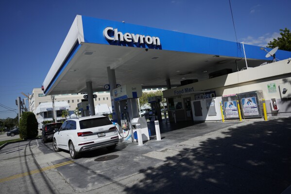 File - Drivers refuel at a Chevron gas station, Monday, Oct. 23, 2023, in South Miami, Fla. A big explanation for the recent decline in gas prices is seasonality — with prices at the pump almost always easing at this time of year. (AP Photo/Rebecca Blackwell, File)