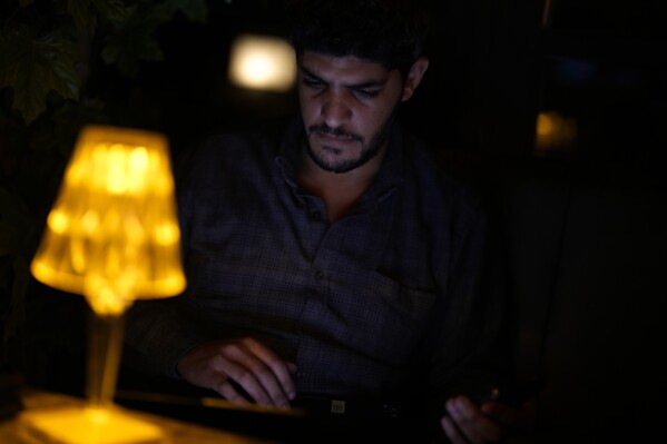 Yousef Salem works on his computer in Istanbul, Turkey, Wednesday, April 17, 2024. In December 2023, in a matter of days, 173 of his relatives were killed in Israeli airstrikes. By spring that toll had risen to 270. He spent months filling a spreadsheet with their vital details as news of their deaths was confirmed, to preserve a last link to the web of relationships he thought would thrive for generations more. “My uncles were wiped out, totally. The heads of households, their wives, children, and grandchildren,” he said. (AP Photo/Khalil Hamra)