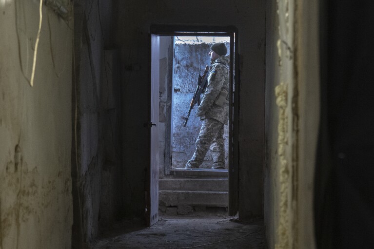 A Ukrainian soldier stands outside a shelter in the front-line city of Kupiansk, Kharkiv region, Ukraine, Thursday, Nov. 30, 2023. (AP Photo/Efrem Lukatsky)