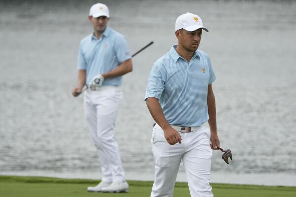 Xander Schauffele walks to the green as Patrick Cantlay looks on the 13th hole during their foursomes match at the Presidents Cup golf tournament at the Quail Hollow Club, Thursday, Sept. 22, 2022, in Charlotte, N.C. (AP Photo/Chris Carlson)