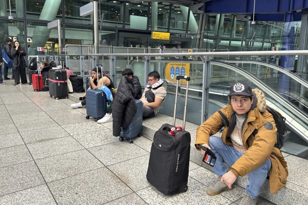 Travellers are waiting as Britain's Heathrow Airport has closed for the full day Friday after an electrical substation fire knocked out its power, disrupting flights for hundreds of thousands of passengers at one of Europe's biggest travel hubs in London, Friday, March 21, 2025.(AP Photo/Kin Cheung)