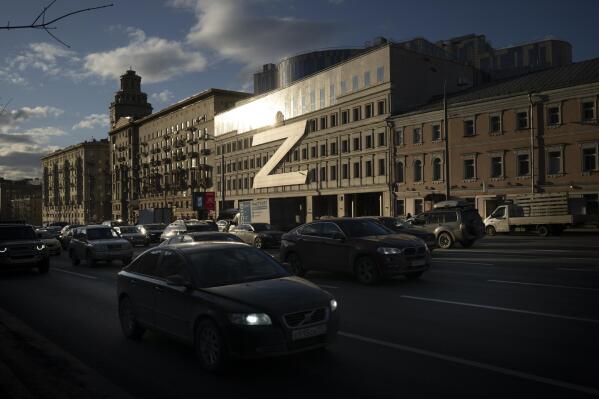 Cars in Moscow, Russia, on Wednesday, March 30, 2022, drive past a building decorated with a huge letter “Z,” which has become a symbol of the Russian military operation in Ukraine, along with a hashtag reading, "We don't abandon our own." The symbols serve as reminders of the conflict that has dragged on for a year. (AP Photo, File)