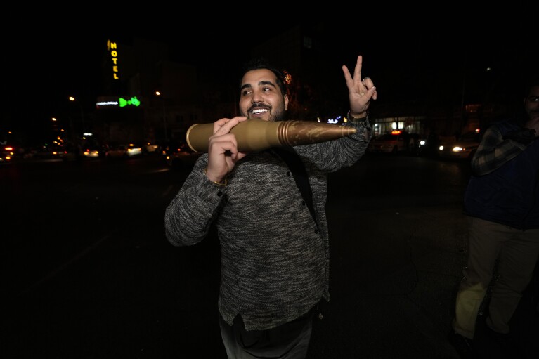 An Iranian demonstrator flashes a victory sign as he holds a model of a bullet during an anti-Israeli gathering at the Felestin (Palestine) Square in Tehran, Iran, early Sunday, April 14, 2024. Iran launched its first direct military attack against Israel on Saturday. (AP Photo/Vahid Salemi)