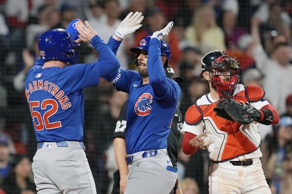 Chicago Cubs' Mike Tauchman, center, celebrates after his three-run home run that also drove in Pete Crow-Armstrong (52) as Boston Red Sox catcher Reese McGuire, right, looks on during the eighth inning of a baseball game, Sunday, April 28, 2024, in Boston. (AP Photo/Michael Dwyer)