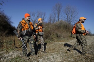Delta Theta Sigma fraternity brothers Tom Kirby, left, Ryan Bostdorf, center and Matt Bosley hunt for deer together on Penn State University farm land in State College, Pa., Wednesday, Dec. 3, 2008. Some online are claiming that hunters in the U.S. outnumber military personnel worldwide. By most measures, this is wrong — but there are different ways to slice the numbers. (AP Photo/Carolyn Kaster)