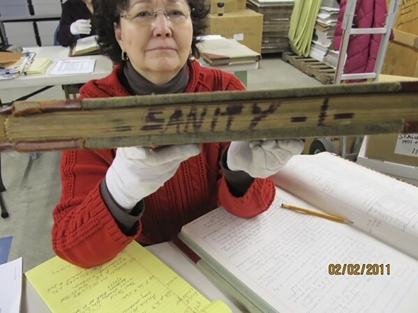 This Feb. 2, 2011, photo shows Niejse Steinkruger at the Alaska state archives in Juneau, Alaska, displaying a book of old court records that included sanity hearings. (Roger Brunner via AP)