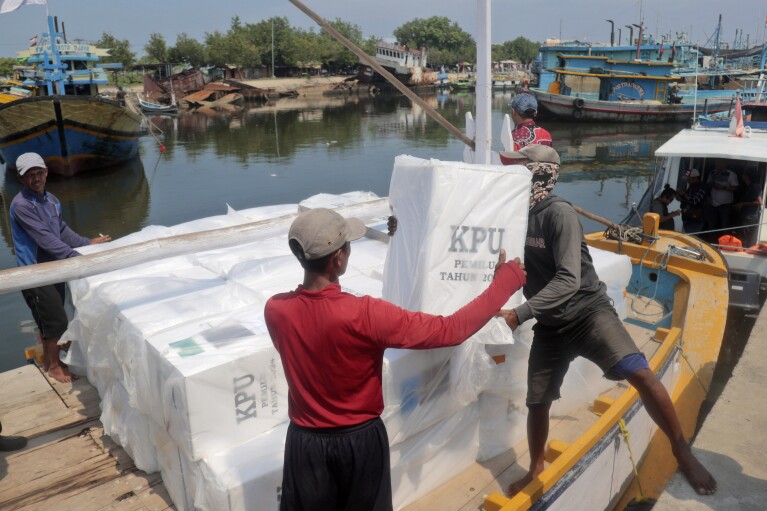 Workers load ballot boxes onto a boat for distribution to polling stations ahead of the February 14 election in Probolinggo, Indonesia, Monday, February 12, 2024. Indonesia, the world's third-largest democracy, begins voting among its roughly 205 million people on Wednesday. The number of voters in presidential and parliamentary elections will be the fifth since Southeast Asia's largest economy began democratic reforms in 1998.  (AP Photo/Tris Nadi)