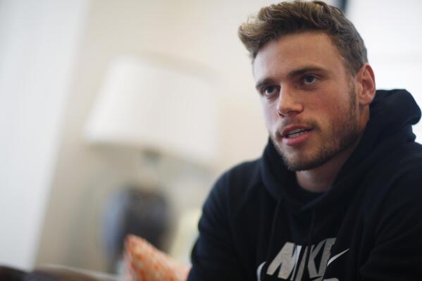 FILE- Gus Kenworthy, a freestyle skier who won a silver medal in Sochi, speaks in his home in Denver on Oct. 21, 2015. “We’re in China, so we play by China’s rules. And China makes their rules as they go, and they certainly have the power to kind of do whatever they want: Hold an athlete, stop an athlete from leaving, stop an athlete from competing,” Kenworthy said on Sunday, Feb. 20, at the 2022 Beijing Olympics. (AP Photo/David Zalubowski, File)