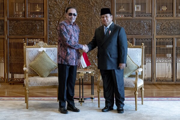 Dalam foto yang disediakan oleh Kantor Perdana Menteri Malaysia, Perdana Menteri Malaysia Anwar Ibrahim, kiri, berjabat tangan dengan presiden terpilih Indonesia dan Menteri Pertahanan Prabowo Subianto di kantor Perdana Menteri di Putrajaya, Malaysia, Kamis, 4 April 2024. (Sadiq Asyraf /Kantor Perdana Menteri Malaysia melalui AP)