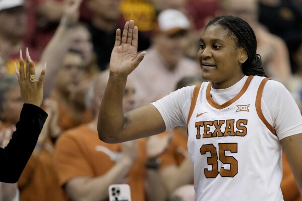 Texas forward Madison Booker celebrates with an assistant coach after an NCAA college basketball game against Iowa State for the Big 12 women's tournament championship Tuesday, March 12, 2024, in Kansas City, Mo. Texas won 70-53. (AP Photo/Charlie Riedel)
