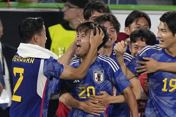 Japan's Takefusa Kubo, center, is celebrated by teammates after his team scored the 4th goal during an international friendly soccer match between Germany and Japan in Wolfsburg, Germany, Saturday, Sept. 9, 2023. Germany lost 1-4.(AP Photo/Martin Meissner)