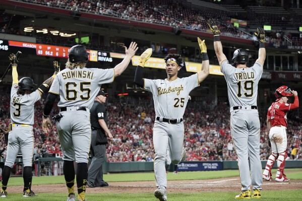 Pittsburgh Pirates' Endy Rodriguez, center, celebrates with Jack Suwinski (65) and Jared Triolo, right, after they scored on a three-run double by Afonso Rivas to tie the score during the seventh inning of a baseball game against the Cincinnati Reds, Saturday, Sept. 23, 2023, in Cincinnati. (AP Photo/Joshua A. Bickel)