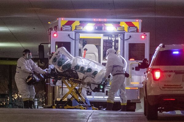 A woman who tested positive with the coronavirus is brought to the University of Nebraska Medical Center,  Friday March 6, 2020. She was transferred from Omaha's Methodist Hospital in an isolation pod inside an ambulance. (Chris Machian/Omaha World-Herald via AP)