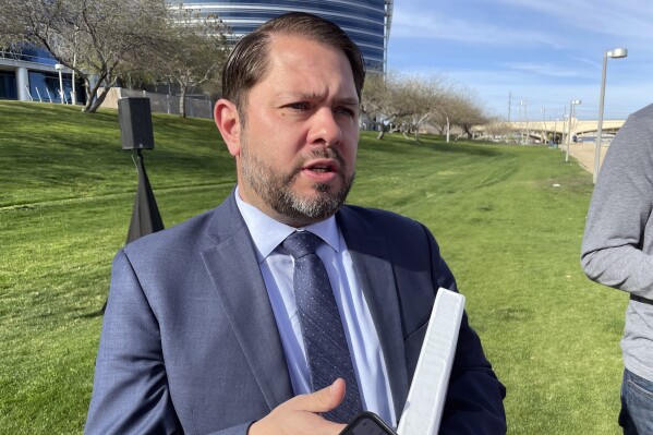FILE - Democrat Ruben Gallego talks to reporters outside the Silicon Valley Bank office in Tempe, Ariz., Tuesday, March 14, 2023. Gallego began airing the first television ads of his U.S. Senate campaign on Tuesday, March 12, 2024, as the crucial Arizona race takes shape as a one-on-one contest after incumbent Kyrsten Sinema declined to run for a second term. (AP Photo/Jonathan J. Cooper, File)