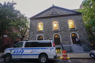 An NYPD patrol car is parked outside a synagogue on the Lower East Side of Manhattan, Saturday, Oct. 7, 2023. (AP Photo/Mary Altaffer)